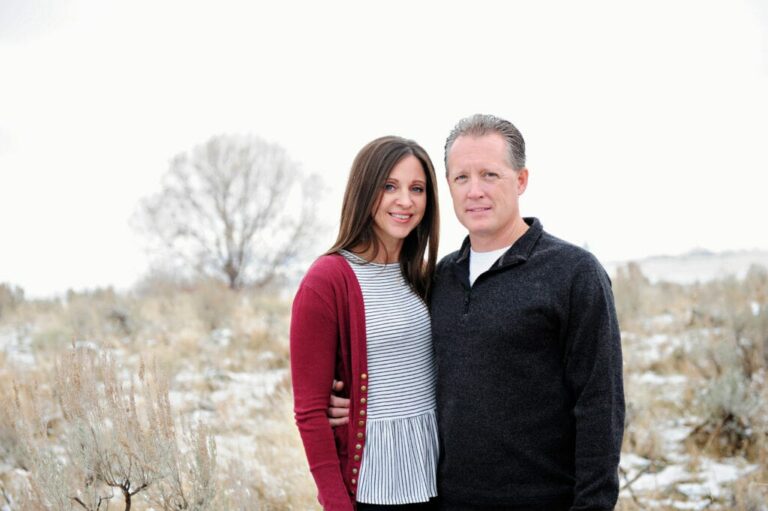 Man and woman in front of field.