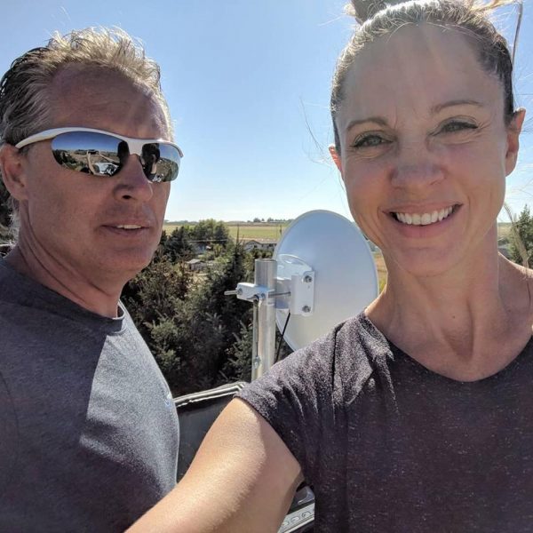 couple smiling in front of internet dish